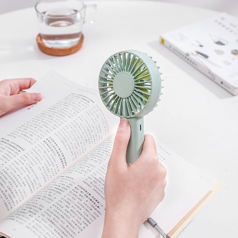 Unisex portable battery-operated mini hand fan with one-button operation and protected fan grill Kalsten