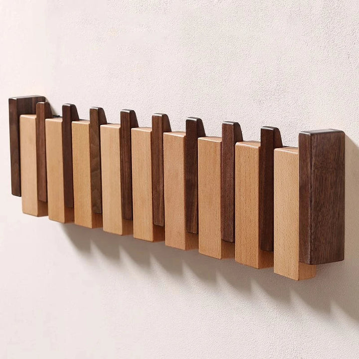 Wooden coat rack in piano design with foldable hooks | Kalsten