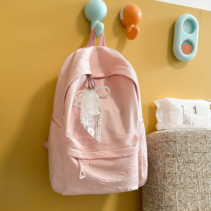 Elegant Textured Backpack with Decorative Charm