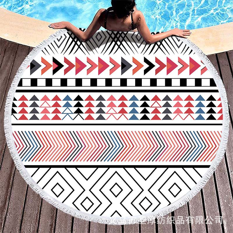 Round beach towel with colorful, tropical floral pattern and fringe decoration Kalsten
