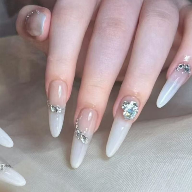 Acrylic nail set with elegant tips and glamorous rhinestone accents Acalora
