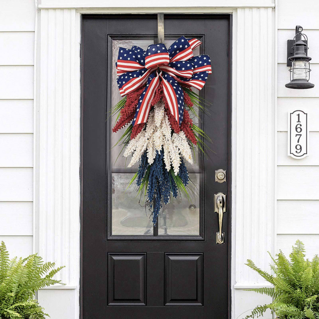 Independence Day tapering teardrop door swag with wired stars-and-stripes bow and textured faux floral sprays Kalsten