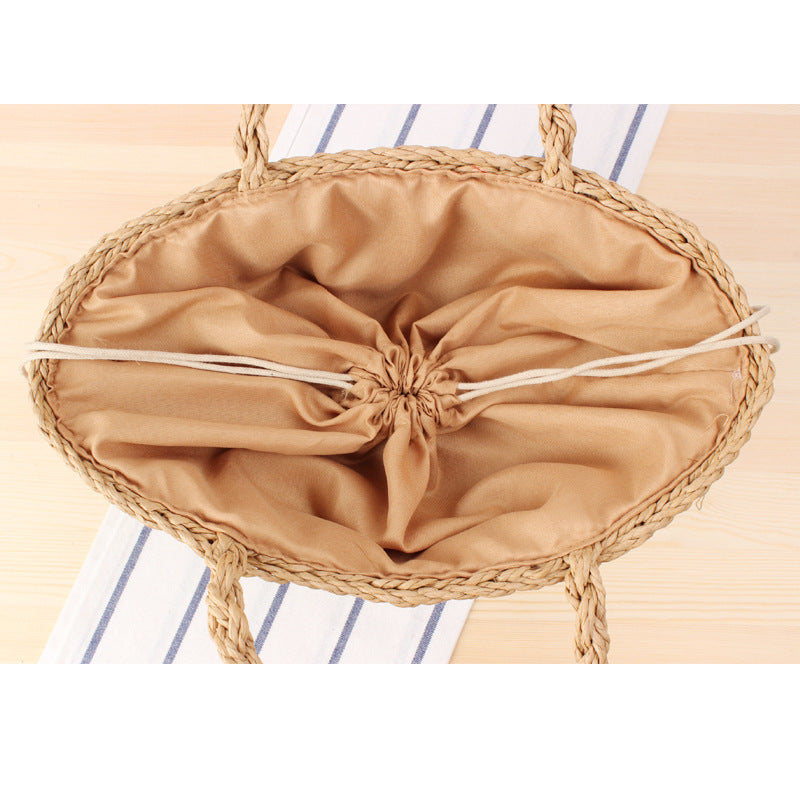 Braided handbag made of natural raffia with robust carrying straps Kalsten