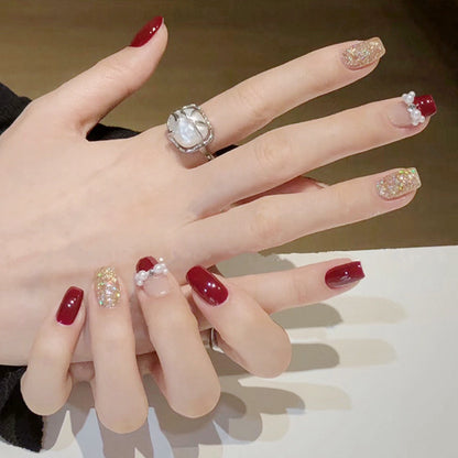 Glamorous artificial nails with glitter and pearl decorations Acalora
