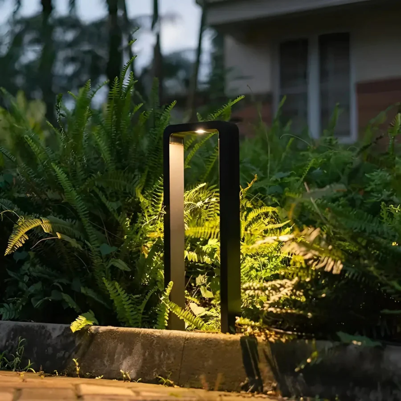 Rechteckige LED-Wegeleuchte in Schwarz beleuchtet Pflanzen am Gartenrand